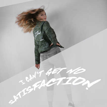 Photograph of teen girl wearing camo jacket and denim jeans with painted music lyrics on them